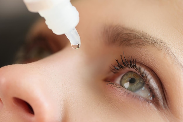 写真 病気に対して医療点眼薬を適用する女性のクローズ アップ