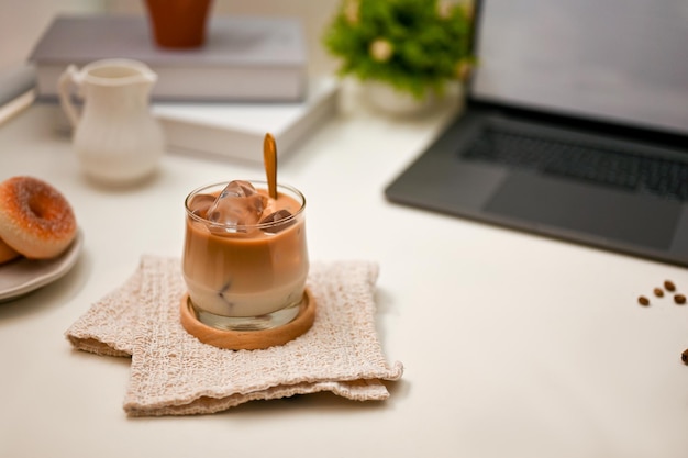 Closeup Office workspace with a glass of iced latte laptop computer and accessories