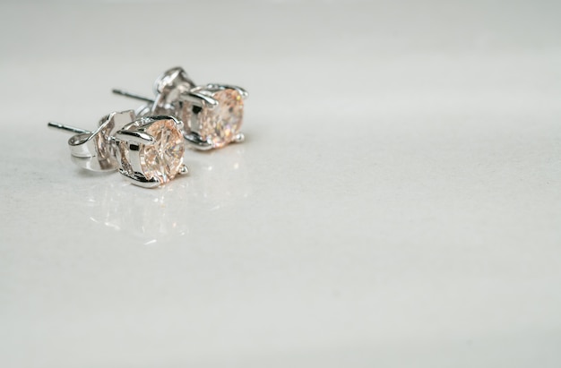 Closeup old diamond earring on blurred marble floor background