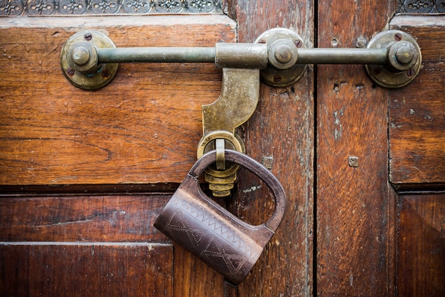 Closeup old door with lock in grungy style and wood texture.