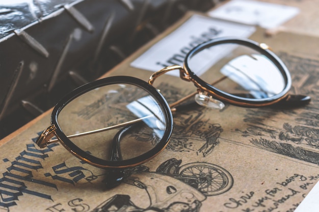 Closeup old glasses and book on wooden table 