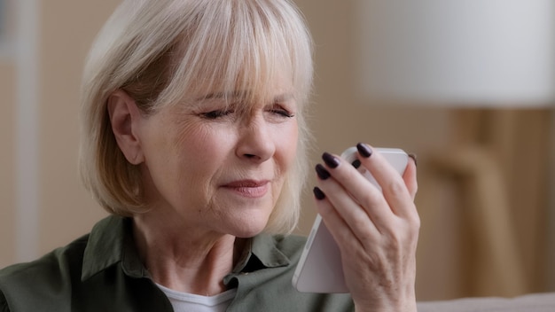 Closeup old lady mature aged grandmother Caucasian retired woman looking at phone screen vision