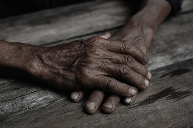 Closeup of old man's hands resting on wood