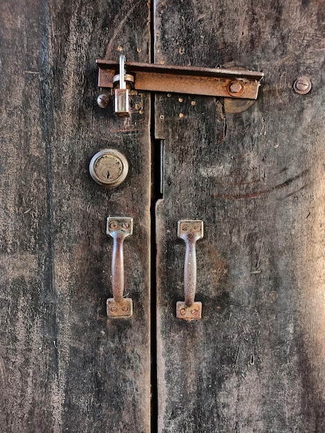 Closeup old rusty lock on the door and broken wood of lock wood background