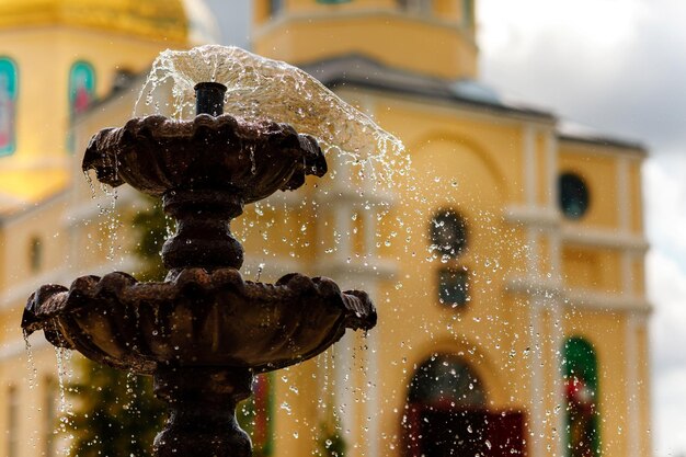 Photo closeup of an old stone fountain with dripping water and blurred background