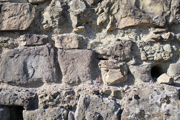 Primo piano del vecchio muro di pietra sfondo scuro roccia superficie natura struttura sfondo grigio