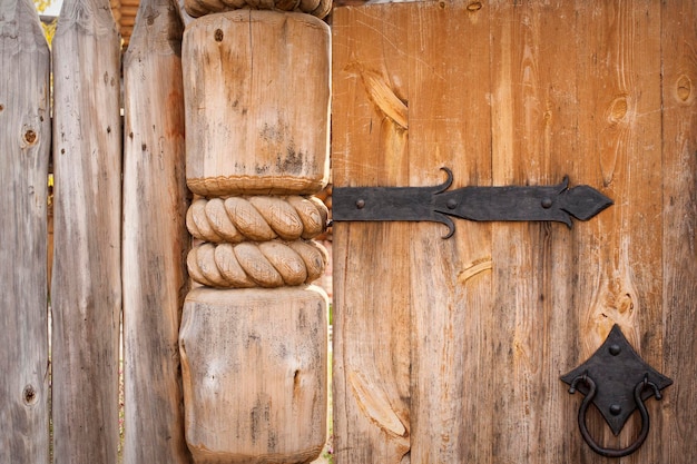 Closeup of old wooden door on metal hinges