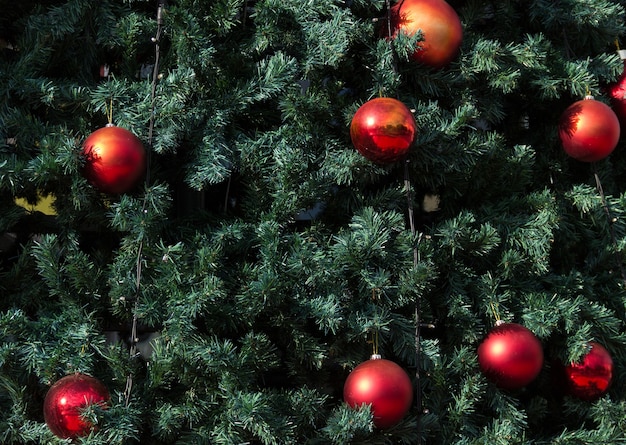 大きな赤いボールと緑のクリスマスツリーのクローズアップ冬の休日の装飾の概念