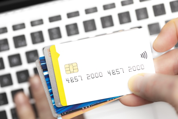 Foto primo piano dell'acquirente online che paga con carte di credito sulla tastiera del computer con spazio di copia