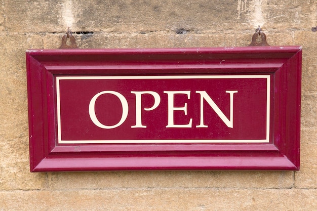 Closeup of Open Sign on Stone Wall