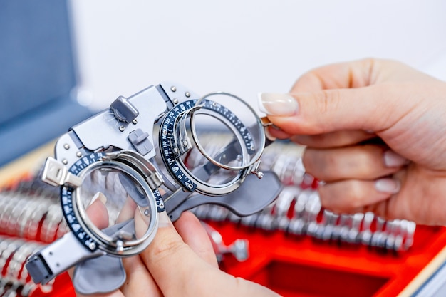 Closeup of ophthalmological trial frame and test glasses in womans hands