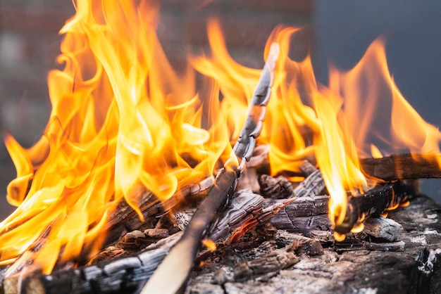 Closeup of Orange flame and charred burning firewood