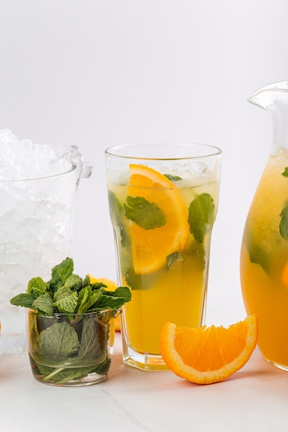 Closeup on orange and mint lemonade in a jug and glass 