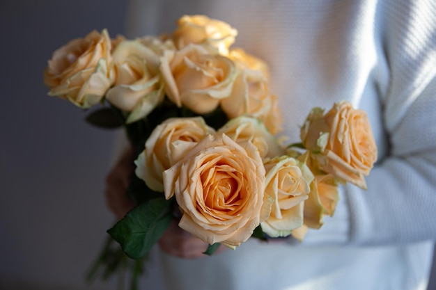 Closeup of orange roses in female hands