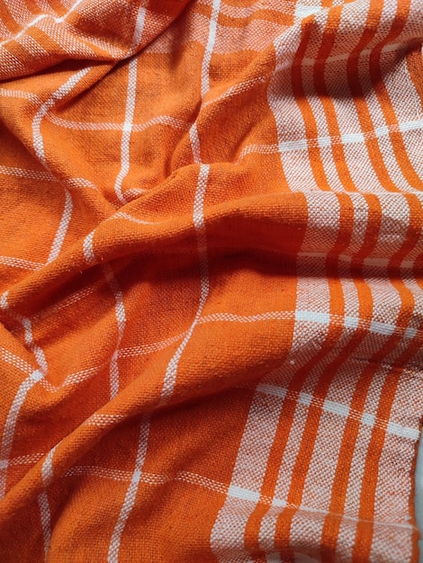 オレンジ色の白いチェッカーのナプキンやピクニック用テーブルクローツのテクスチャのクローズアップ キッチンアクセサリー