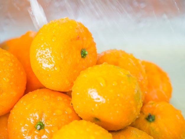 Closeup of oranges and drops. Cleaning fruits with water.