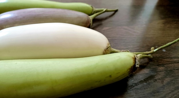 Primo piano di melanzane fresche bianche e verdi organiche o melanzane isolate su fondo di legno