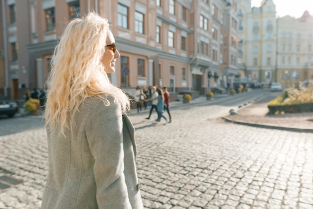 Closeup outdoor portrait of young smiling blond woman