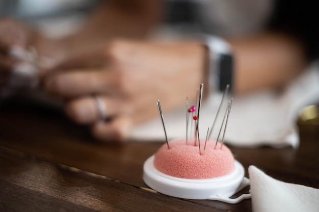 Closeup pad for needles at professional sewing workshop during seamstress working