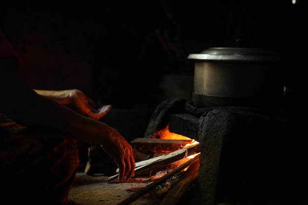 Closeup of pan above firewood burned at traditional\
kitchen