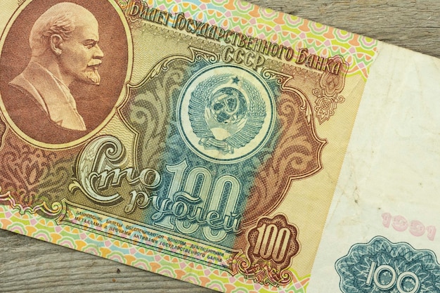A closeup of a paper bill from the USSR worth 100 rubles with a portrait of Lenin