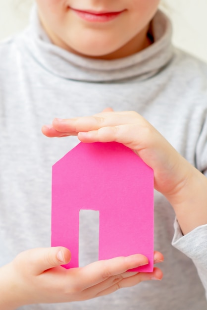 Closeup of paper house in hands of child