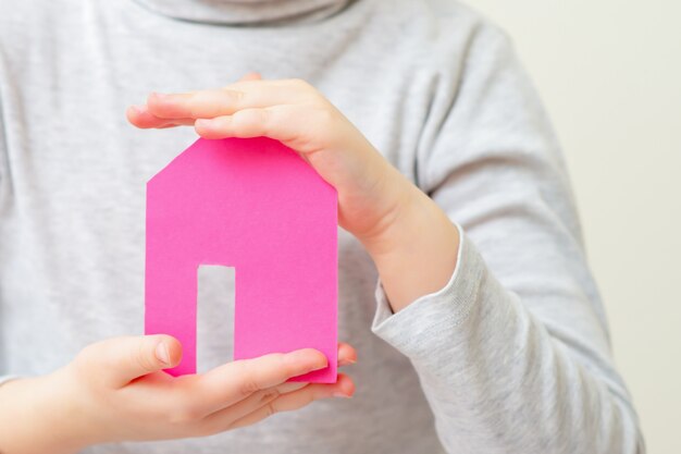 Closeup of paper house in hands of child