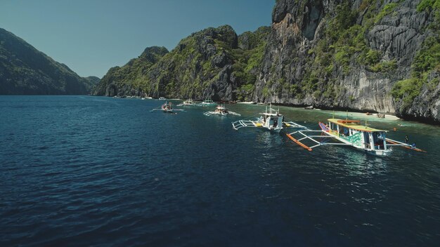 Photo closeup passenger boats at ocean coast with cliff shore at summer tour serene tropical nature scape