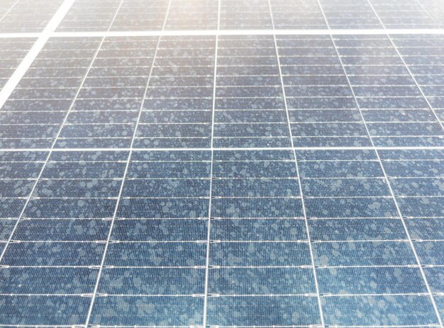 Foto close-up del modello della cella solare fotovoltaica con la goccia di pioggia sul tetto del magazzino per l'uso come energia alternativa vista frontale con lo sfondo