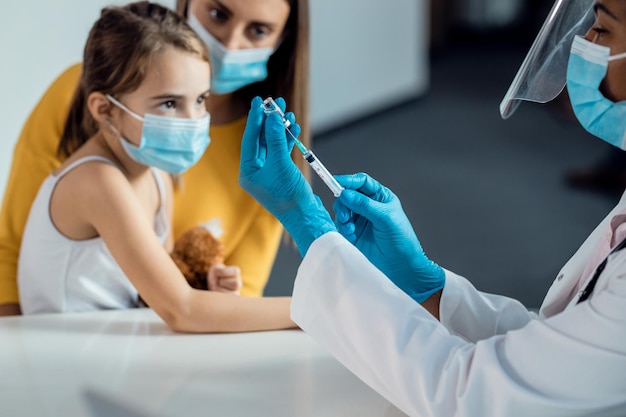 Closeup of pediatrician preparing a vaccine for a child during coronavirus pandemic