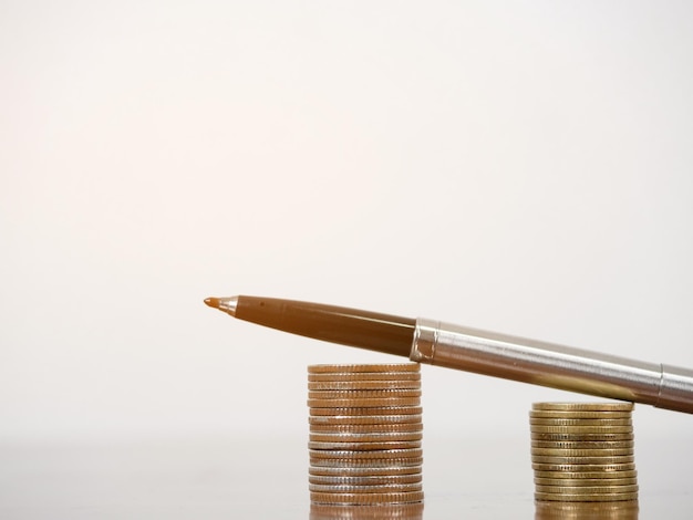 Closeup pen op munten opgroeien op de tafel witte achtergrond kopie ruimte