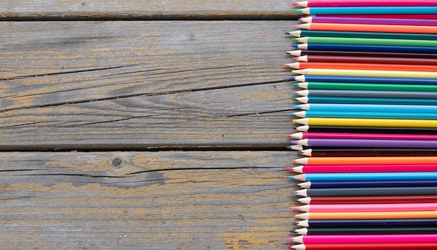 Closeup of pencil on old wood planks texture and grass surface