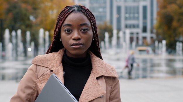 クローズ アップ物思いにふける深刻なアフリカ系アメリカ人女性の立っている秋の市若い女の子の学生マネージャー