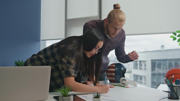 Photo closeup people analyzing blueprint coworking place confident man telling ideas