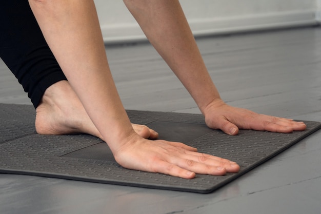 Closeup of a person doing yoga or fitness on a black mat