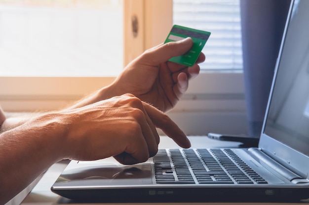 Closeup of a person filling his credit card details on a laptop concept of online shopping