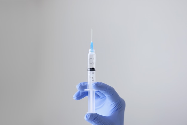 Closeup of person hand holding syringe with transparent substance injection