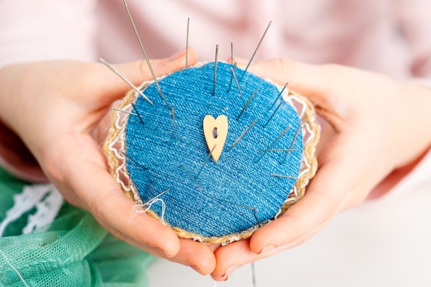 Closeup of person holding pincushion full of needles