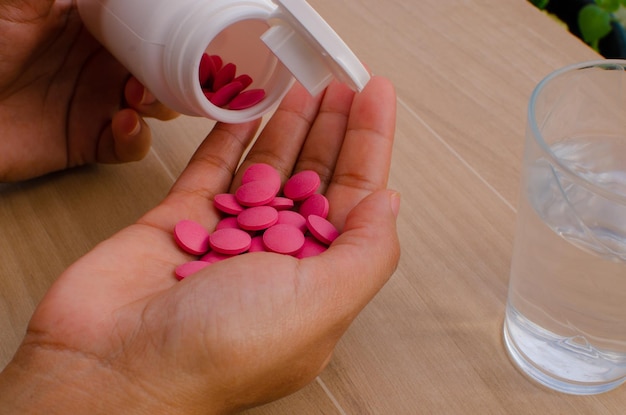 Closeup person holding and taking pills Medical composition with pills Health and pills packaging.