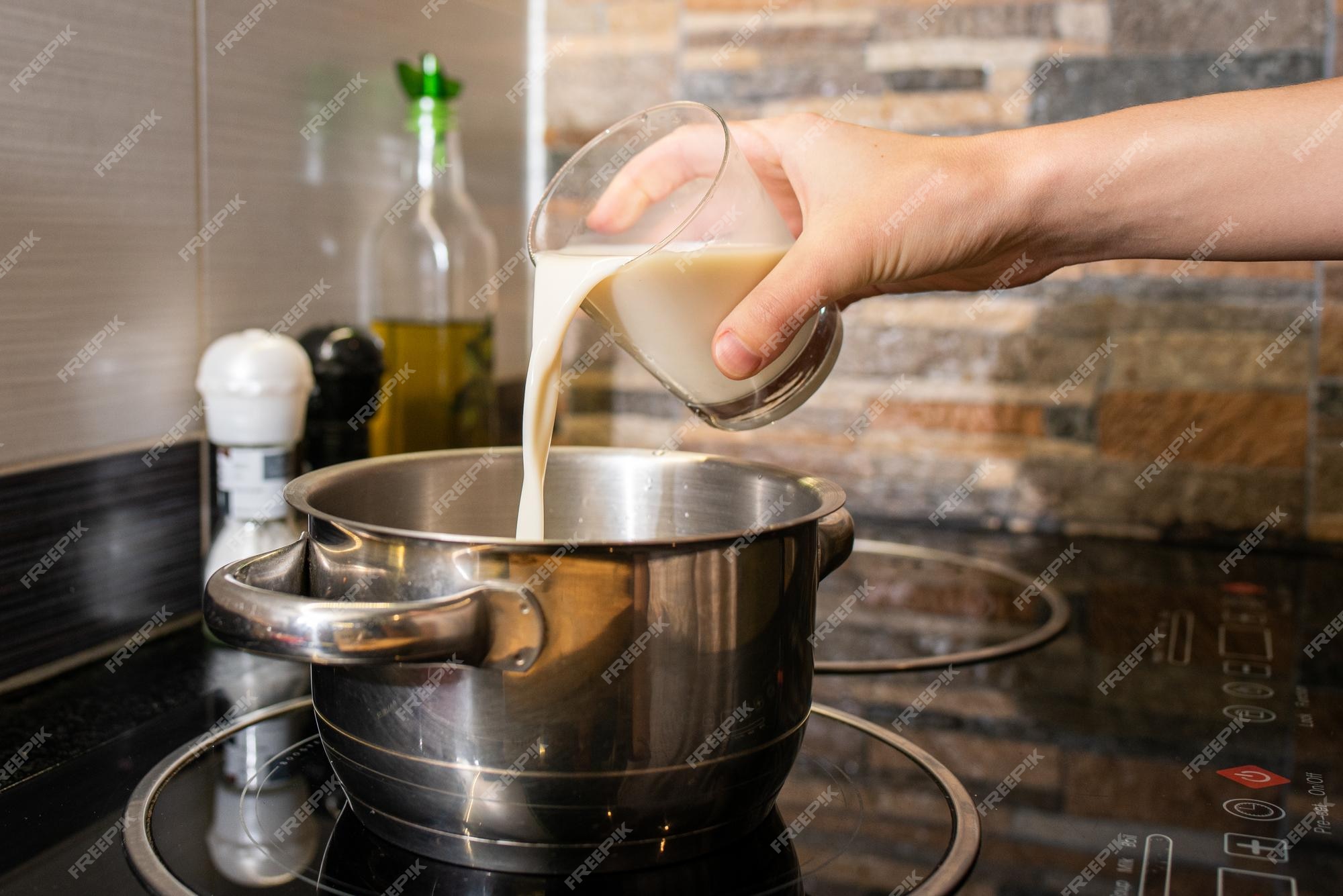 Premium Photo  Closeup of a person making oatmeal with milk in a pot on  the stove