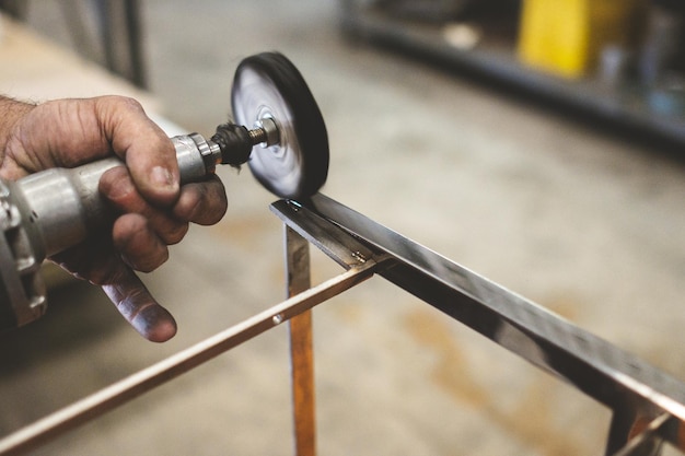 Photo closeup of a person polishing steel under the lights in a garage