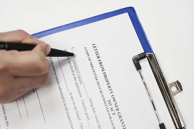Photo closeup of a person signing a property authorization letter