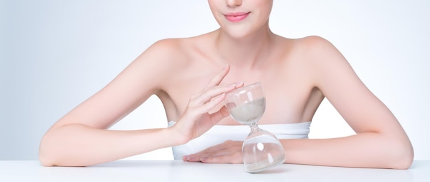 Closeup personable beautiful woman with hourglass as antiaging skincare concept