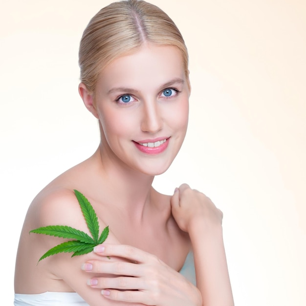 Closeup personable woman hold green leaf as cannabis beauty concept