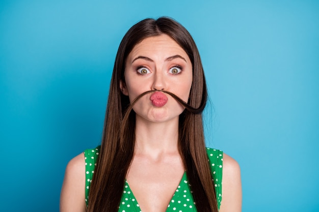 Closeup photo of attractive funny lady play curl make fake mustache pretend guy behavior send air kisses wear green summer cropped top tank-top isolated blue color background