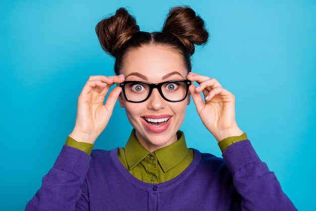 Closeup photo of attractive shocked lady two funny buns crazy
good mood try on new vision specs amazed perfect view wear shirt
collar violet sweater isolated blue color background