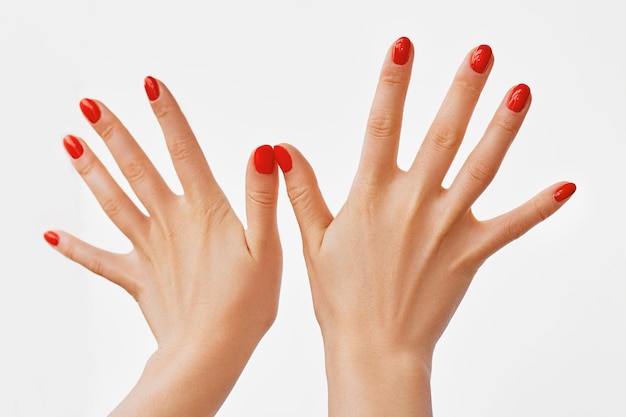 Closeup photo of a beautiful female hands with red nails isolated on white background