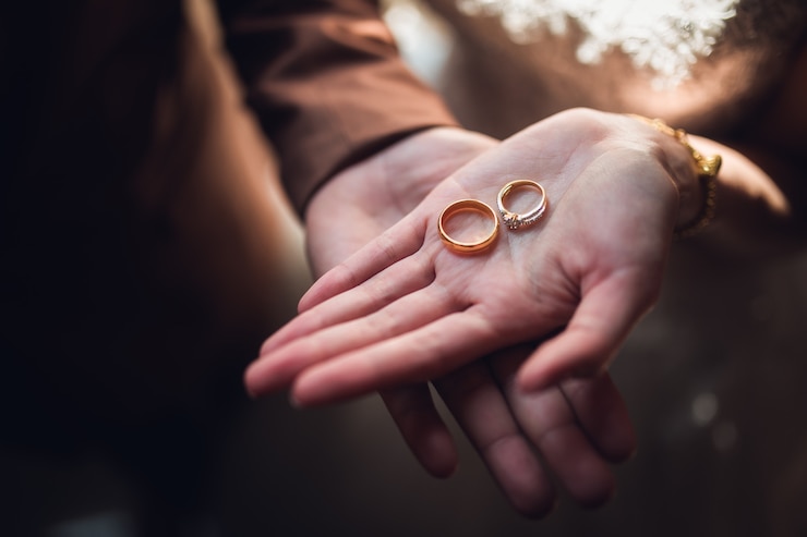 Photo closeup photo of bride and groom holding golden wedding rings on hands 