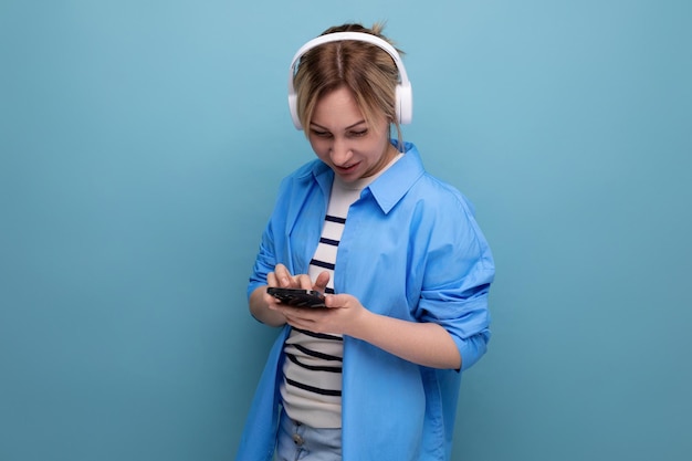 Closeup photo of a bright smiling blond young woman dressed in a striped sweater and casual shirt