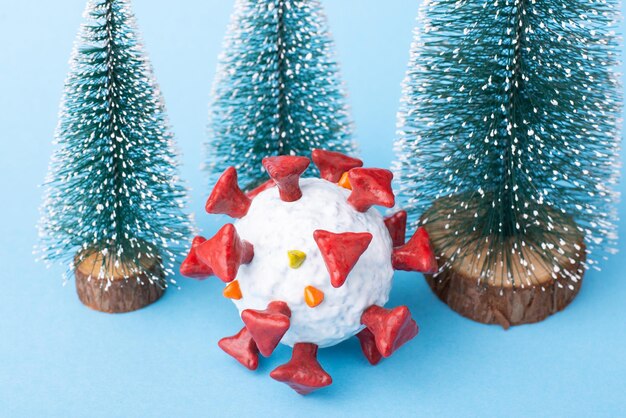 Closeup photo of Coronavirus near small christmas trees